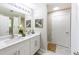 Bright bathroom features double sink vanity with modern fixtures, white cabinets and framed mirrors at 5885 Waggoner Cv, Rex, GA 30273
