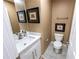 Small bathroom with gray tiled floor, white vanity with mirror and lighting, and toilet at 5885 Waggoner Cv, Rex, GA 30273