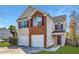 Inviting two-story home featuring a double garage, red shutters, and a well-maintained front lawn at 5885 Waggoner Cv, Rex, GA 30273