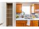 Kitchen with stainless steel sink, granite counters, wood cabinets and adjacent walk-in pantry with shelving at 5885 Waggoner Cv, Rex, GA 30273