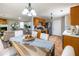Open-concept kitchen and living room featuring warm lighting, stainless appliances, and wood cabinets at 5885 Waggoner Cv, Rex, GA 30273