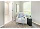 Cozy sitting area features a white accent chair, side table, a patterned pillow, and a window at 5885 Waggoner Cv, Rex, GA 30273