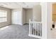 Upstairs landing area with neutral carpet, double closet, and view of the staircase and bathroom at 5885 Waggoner Cv, Rex, GA 30273