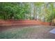 Fenced backyard with a well-manicured lawn and mature trees, offering privacy at 2545 Davenport Park Dr, Duluth, GA 30096