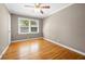 Bright bedroom features hardwood floors, a ceiling fan and a large window with green views at 3188 Sunnyford Ln, Lithonia, GA 30038