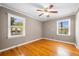Bright bedroom with hardwood floors, two windows, and a ceiling fan at 3188 Sunnyford Ln, Lithonia, GA 30038