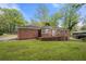 Brick home with a sprawling lawn, rear patio, and multiple windows overlooking the backyard at 3188 Sunnyford Ln, Lithonia, GA 30038