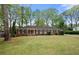 Charming single-story brick home with a well-manicured lawn, black shutters, and a symmetrical facade at 3188 Sunnyford Ln, Lithonia, GA 30038