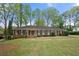 Charming single-story brick home with a well-manicured lawn and mature trees in a peaceful neighborhood at 3188 Sunnyford Ln, Lithonia, GA 30038