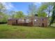 Brick house with large lawn, patio, many windows, and a driveway to the side at 3188 Sunnyford Ln, Lithonia, GA 30038