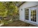 Back deck with sliding glass doors to the home surrounded by lush green trees at 507 Matthew Dr, Canton, GA 30115