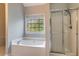 Relaxing bathroom with a soaking tub, shower with glass door, and a window at 507 Matthew Dr, Canton, GA 30115