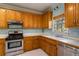 Well-lit kitchen with wood cabinets, stainless steel appliances, and a view from the window at 507 Matthew Dr, Canton, GA 30115