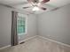Neutral bedroom with large window providing natural light and ceiling fan at 5711 Parks Rd, Cumming, GA 30041