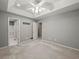A light and bright bedroom with a tray ceiling, ensuite bathroom and plush carpet at 5711 Parks Rd, Cumming, GA 30041