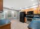Cozy kitchen features wood cabinets, stainless steel appliances, tile flooring, and bright windows at 5711 Parks Rd, Cumming, GA 30041