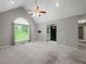 Bright living room featuring neutral walls, vaulted ceiling, ceiling fan, and large window with abundant natural light at 5711 Parks Rd, Cumming, GA 30041