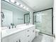 This bathroom features a double vanity, a large mirror, and glass enclosed shower with attractive tile work at 6815 Fairgreen Dr, Suwanee, GA 30024