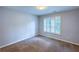 This bedroom features neutral walls, cozy brown carpeting and a bright window with white shutters at 6815 Fairgreen Dr, Suwanee, GA 30024