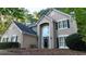 View of front exterior with manicured lawn, landscaped yard, and bench by front door at 6815 Fairgreen Dr, Suwanee, GA 30024