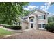 Charming two-story home featuring an inviting entrance, arched window, and manicured landscaping at 6815 Fairgreen Dr, Suwanee, GA 30024