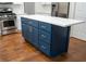 A blue kitchen island features white marble countertop, cabinets, and drawers at 6815 Fairgreen Dr, Suwanee, GA 30024