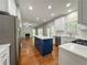 Bright kitchen features white countertops, stainless appliances, and a blue kitchen island at 6815 Fairgreen Dr, Suwanee, GA 30024