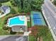 Aerial view of the pool and tennis court surrounded by lush greenery and manicured landscaping at 6815 Fairgreen Dr, Suwanee, GA 30024