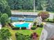 Aerial view of community pool and tennis court surrounded by lush greenery and manicured landscaping at 6815 Fairgreen Dr, Suwanee, GA 30024