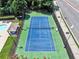 Aerial view of the community tennis court, pool and surrounding landscape at 6815 Fairgreen Dr, Suwanee, GA 30024