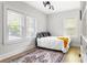 Bright bedroom with hardwood floors, white walls, natural light, and decorative area rug at 812 E Ponce De Leon Ave, Decatur, GA 30030