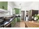 Charming kitchen features green cabinets, black countertops, stainless steel appliances, and bright lighting at 812 E Ponce De Leon Ave, Decatur, GA 30030