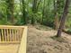 Landscaped backyard with a wooden deck and wooded area in the background at 2065 Verbena St, Atlanta, GA 30314