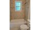Cozy bathroom featuring neutral-toned tile, a bathtub, shower, and window at 2065 Verbena St, Atlanta, GA 30314