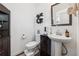 Well lit bathroom with a pedestal sink, open shelving, and light walls and dark cabinet at 3533 Settlement Rd, Tucker, GA 30084