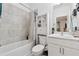 Bright bathroom featuring a shower-tub combo, gray-tiled walls, and a modern white vanity at 3533 Settlement Rd, Tucker, GA 30084