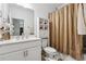 Bathroom with a shower-tub combo, golden curtains, white vanity, and decorative elements at 3533 Settlement Rd, Tucker, GA 30084