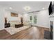 Bright living room featuring a fireplace, balcony access, and hardwood flooring at 3533 Settlement Rd, Tucker, GA 30084