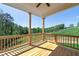 Covered back porch with wood flooring and a serene view of the lush greenery, perfect for outdoor relaxation and entertaining at 4725 Young Deer Dr, Cumming, GA 30041