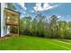 Lush green backyard featuring a covered porch and wooded surroundings, perfect for outdoor enjoyment and relaxation at 4725 Young Deer Dr, Cumming, GA 30041
