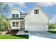 Charming two-story home features a classic white facade, complemented by a well-manicured lawn and attached two-car garage at 4725 Young Deer Dr, Cumming, GA 30041