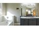 Bathroom with double sinks, vanity, and large mirror over gray cabinets at 5070 Smithfield Rd, Bowdon, GA 30108