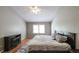 Bedroom with vaulted ceiling, electric fireplace, window and wood flooring at 5070 Smithfield Rd, Bowdon, GA 30108