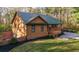Charming house featuring wood siding, a green metal roof, front porch, and a well-manicured lawn at 5070 Smithfield Rd, Bowdon, GA 30108