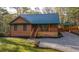 Charming cabin with wood siding, metal roof, front porch, and gravel driveway at 5070 Smithfield Rd, Bowdon, GA 30108