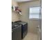 Functional laundry room featuring modern appliances, shelving, and natural light at 1104 Aqua Shore Dr, Mcdonough, GA 30252