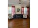 Bright living room showcasing hardwood floors, armchairs, a fireplace, and large windows with stylish curtains at 1104 Aqua Shore Dr, Mcdonough, GA 30252
