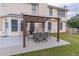 Relaxing back patio with an elegant pergola-covered dining set for outdoor enjoyment at 115 Westbury Ln, Johns Creek, GA 30005