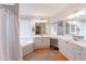 Bright bathroom featuring double vanity, soaking tub, and wood-look flooring for a spa-like retreat at 115 Westbury Ln, Johns Creek, GA 30005