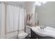 Bathroom with black vanity, framed mirror, and a shower-tub combo with a decorative curtain and dark wood floors at 115 Westbury Ln, Johns Creek, GA 30005